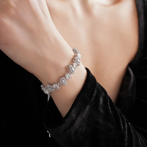 Close-up of adjustable silver bracelet with zircon water drop charms on a wrist