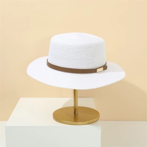 Detail of white woven straw hat featuring a brown leather band and gold buckle