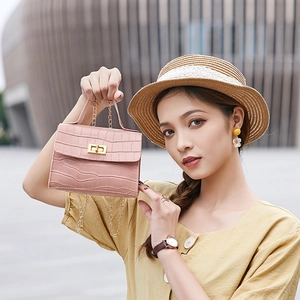 Pink crocodile-embossed Kelly-style handbag with golden clasp and chain strap