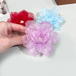 Gros plan de pinces à cheveux roses en organza faites main en rouge, bleu et violet