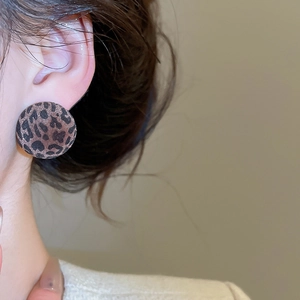 Close-up of a model wearing leopard print round flocking stud earrings for autumn style