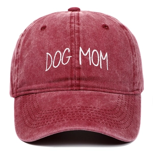 Close-up of white DOG MOM embroidery on washed burgundy cotton baseball cap