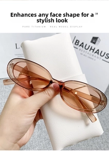 Detail of amber cat eye sunglasses held by hand with a white leather case background