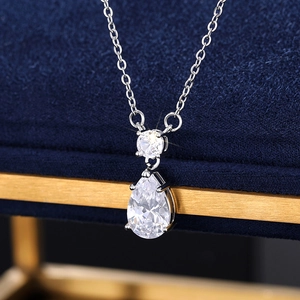 Gros plan d'un collier avec pendentif en cristal en forme de goutte dans son écrin