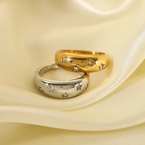 Elegant gold and silver star pattern rings with sparkling zircon on silk background