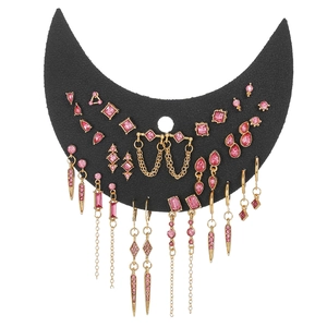 Parure de boucles d'oreilles gothiques dorées et pierres roses sur présentoir