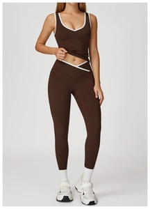 Detail van een high-waist yogabroek met V-vormige contrastband en slankmakende naatlijnen