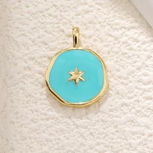 Macro shot of irregular sky blue enamel pendant with a golden star on white texture