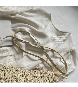 Detailed macro view of woven straw bag showing the natural texture and braided strap