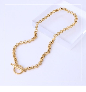 Detail of chunky gold chain necklace featuring an OT toggle clasp on acrylic block