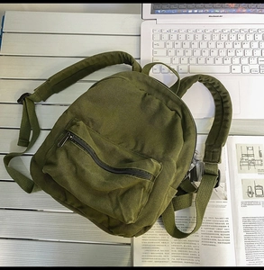 Nahaufnahme des militärgrünen Canvas-Rucksacks mit Stoffstruktur auf dem Tisch