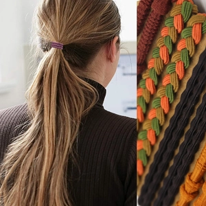 Detail of woven elastic hair ties in multiple colors worn on a blonde ponytail style