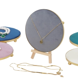 Close-up of velvet jewelry display stands with gold trim and wooden easel support