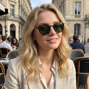 Close-up of retro metal round sunglasses with dark lenses on a model in street style