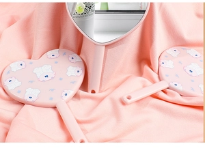 Detailed view of pink heart-shaped handheld mirrors featuring cute cartoon sheep patterns