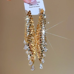 Macro shot of gold plated mesh tassel earrings with zircon teardrop crystal pendants