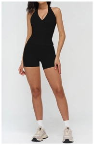 Front view of a black two-piece yoga set with halter V-neck and high-waisted shorts