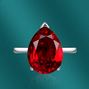 Macro shot of pear-cut red ruby ring with high-polish silver claw setting