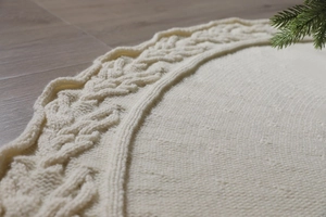 Macro detail of creamy white knitted Christmas tree skirt with cable knit patterns
