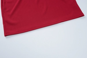 Gros plan détaillé du tissu en maille côtelée rouge et de la double couture de l'ourlet