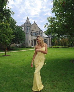 Détail d'une robe de soirée jaune dos nu avec des accents floraux 3D sur les bretelles