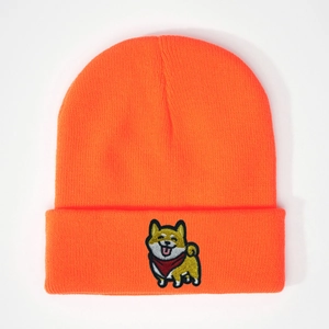 Détail du bonnet en tricot orange vif avec une jolie broderie de dessin animé Shiba Inu