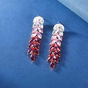 Macro detail of leaf-shaped drop earrings with pink gradient zircons in gold setting