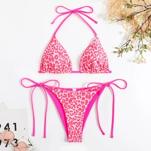 Flat lay of pink leopard print bikini with halter top, side ties and beach accessories