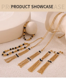 Detail of vintage gold chain jewelry set with black beads and long tassels on white props