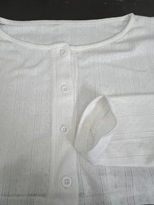 Détail du tissu en maille blanche pour vêtements de détente avec rayures et fermeture à boutons