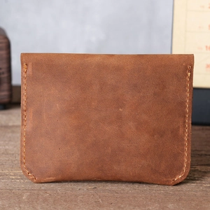 Close-up of vintage brown crazy horse leather card holder with detailed beige stitching