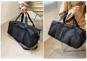 Detail view of black travel duffle bag with reinforced handles and adjustable shoulder strap