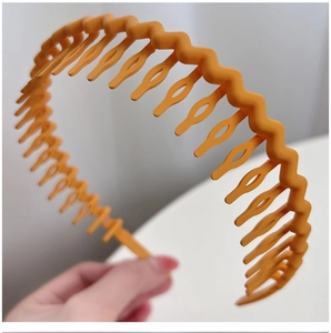 Close-up of orange wavy headband with inner comb teeth for non-slip hair styling