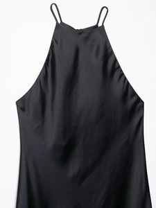 Detail of glossy black silk satin fabric and halter strap texture on a dress