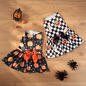 Halloween pumpkin pet dresses for small dogs with festive bows on wooden background