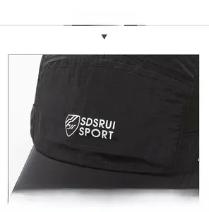 Detail of black quick-dry baseball cap featuring mesh texture and sport logo