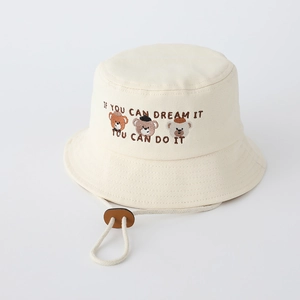 Detail showing bear embroidery and adjustable windproof strap on beige canvas bucket hat