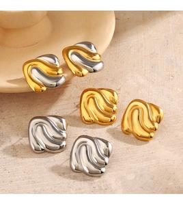Detail of geometric wavy square stud earrings in gold and silver on stone base