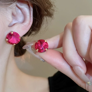 Detail of pink round rhinestone earrings with gold setting worn by a model