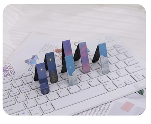 Detailed view of six magnetic bookmarks with scenic cloud designs on a computer keyboard
