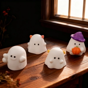 Cute Halloween ghost candles set with wizard hat and pumpkin on a dark wood background