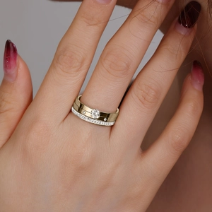 Close-up of stacked gold and silver titanium rings with round brilliant-cut diamonds