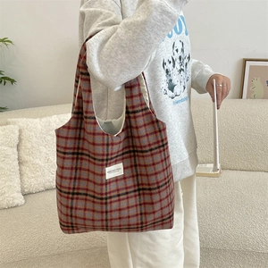 Detail of vintage plaid tote bag with red-brown wool fabric in a cozy home setting