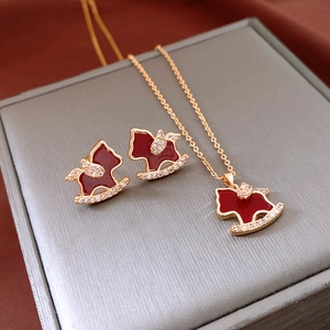 Detail of 18K gold plated horse jewelry set with red enamel and sparkling crystals