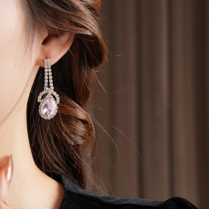 Detail of pink teardrop gemstone earrings with rhinestones on silver metal setting