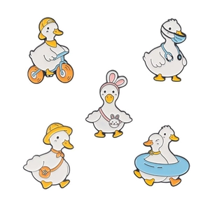 Set of five cute cartoon yellow duck enamel pins featuring cycling and swimming designs