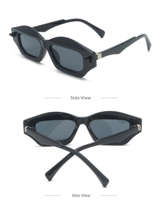 Detail view of black geometric polygon sunglasses with silver metal accents and gray lenses