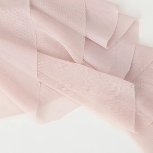 Pink sheer mesh fabric close-up with soft ruffles and delicate micro-grid texture