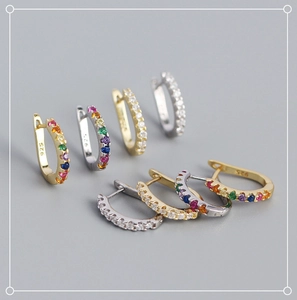 Macro shot of S925 sterling silver U-shaped huggie earrings with clear and rainbow cubic zirconia