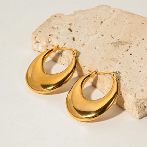 Detail of 18K gold-plated stainless steel oval teardrop earrings on a stone base